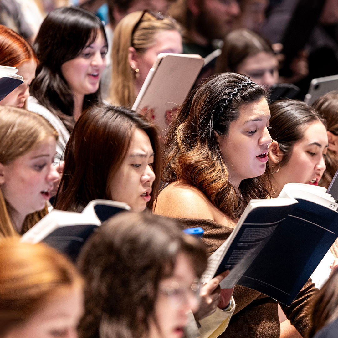 CCM Choirs perform on stage. 