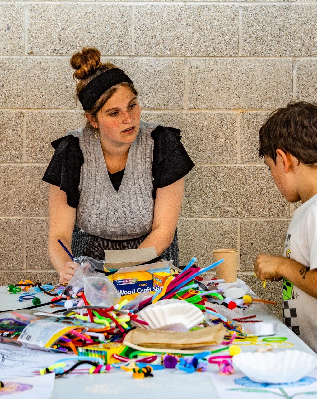 UC graduate student Annika Baldwin talks science with a child at Northside Farmers Market. 