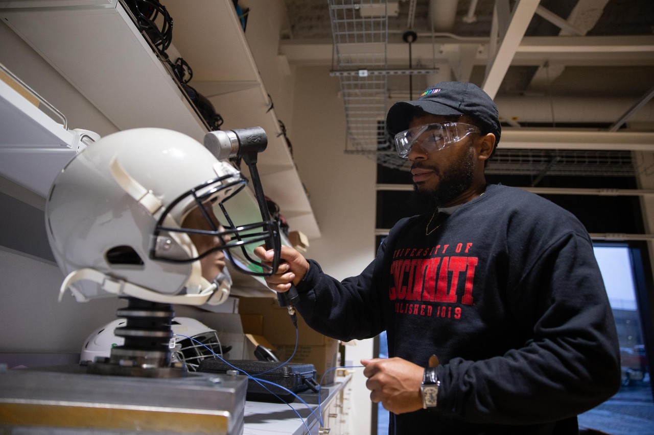 Led by Dr. Eric Nauman, a professor of biomedical engineering in UC’s College of Engineering and Applied Science, University of Cincinnati engineers put popular football helmets made by leading brands through impact testing and found that no single design demonstrated superior reduction of potential concussion incidence or consistent energy absorption at every part of the helmet. Research assistants: Sean Bucherl (ball cap), Christopher Boles (UC sweatshirt), and Shengming Hu (UC polo).