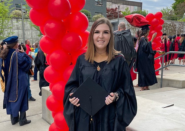 Erica Neff poses in cap and gown following UC commencement ceremonies