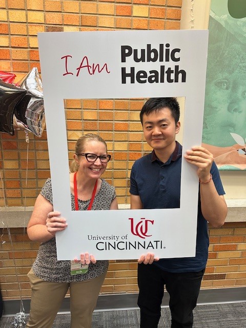 Mentor and mentee pair posing with public health sign