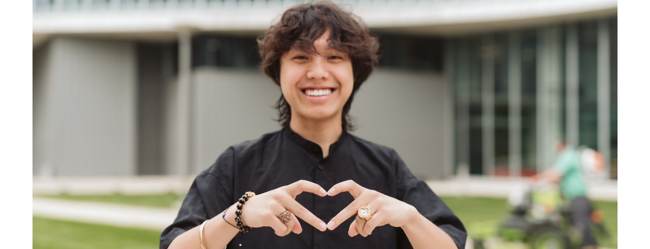 student making a heart with their hands