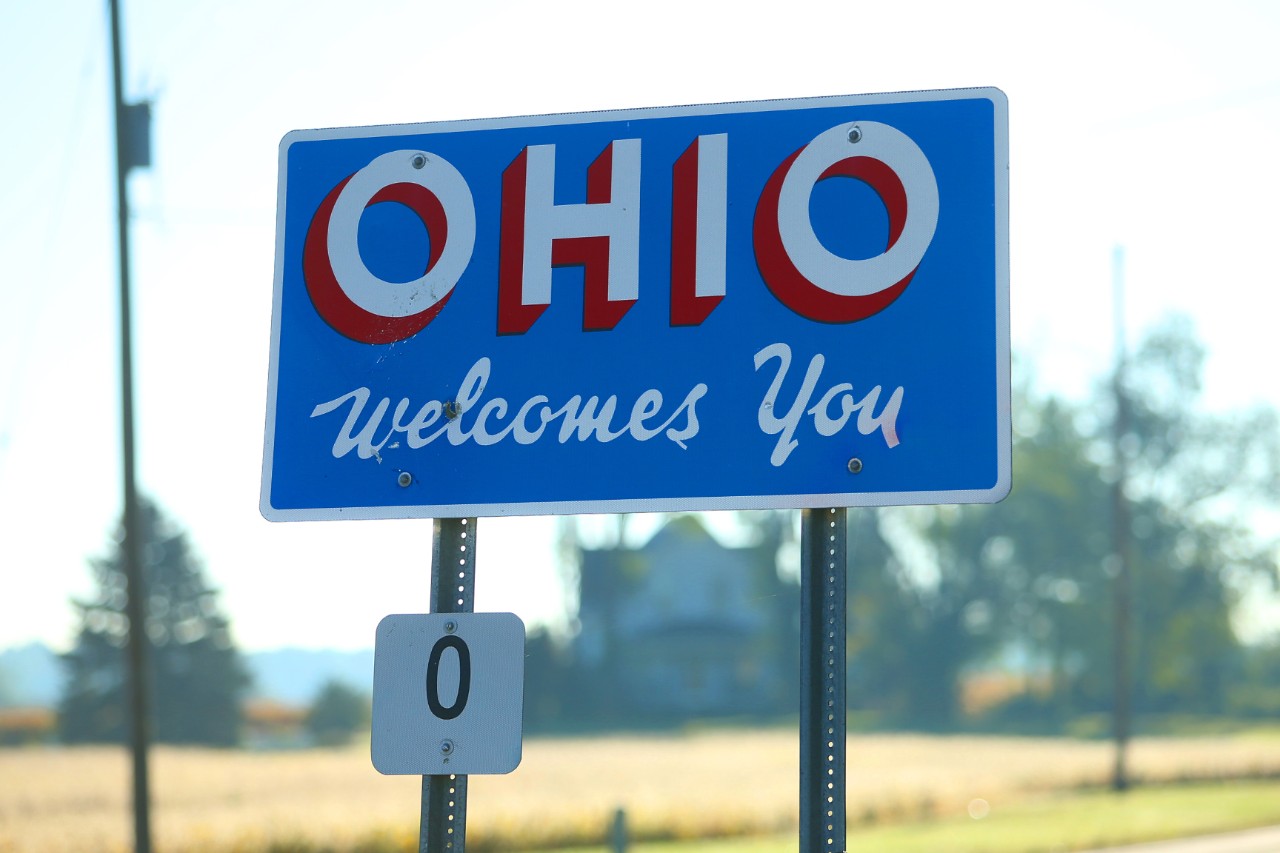Welcome to Ohio sign along a rural farm road at the Ohio/Michigan state line.