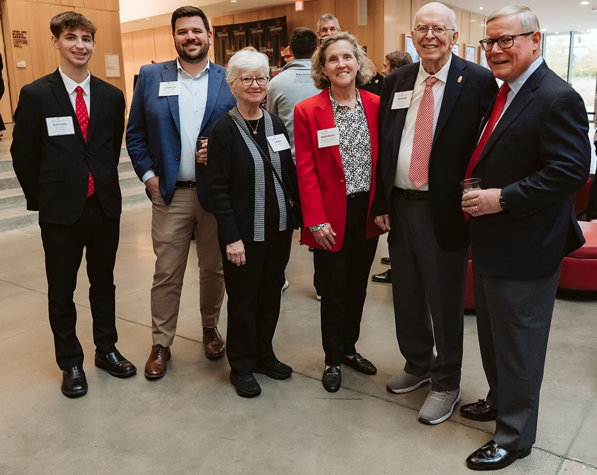 A group of people including a student, alumni and Honors supporters pose for a picture.