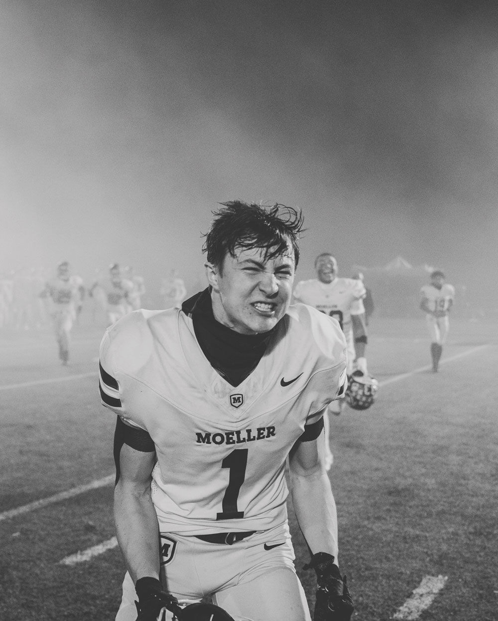 Black and white photograph of a high school football player yelling in celebration