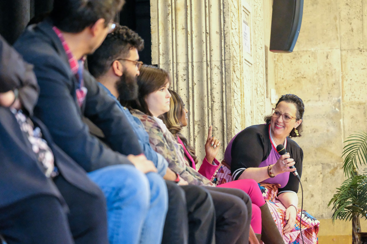 Victoria LaPoe uses a microphone to talk to other people on stage.