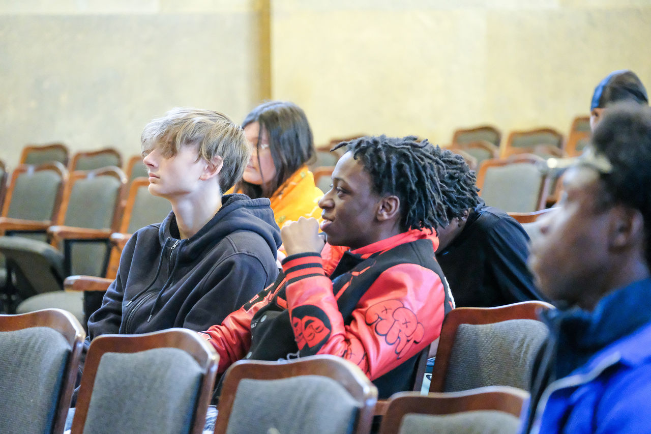 Students listen while seated in an auditorium. 