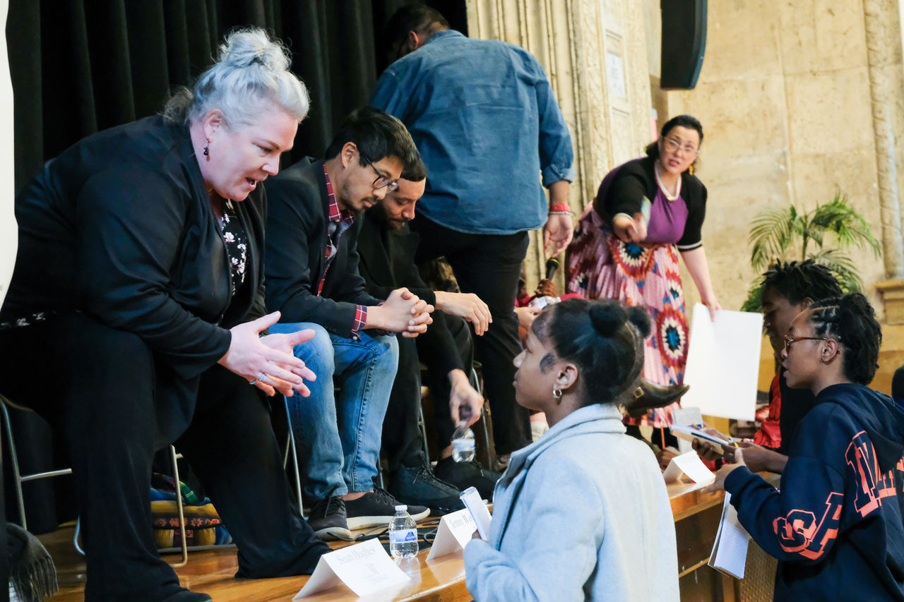 Panelists talk to students from the stage at the Oyler School.