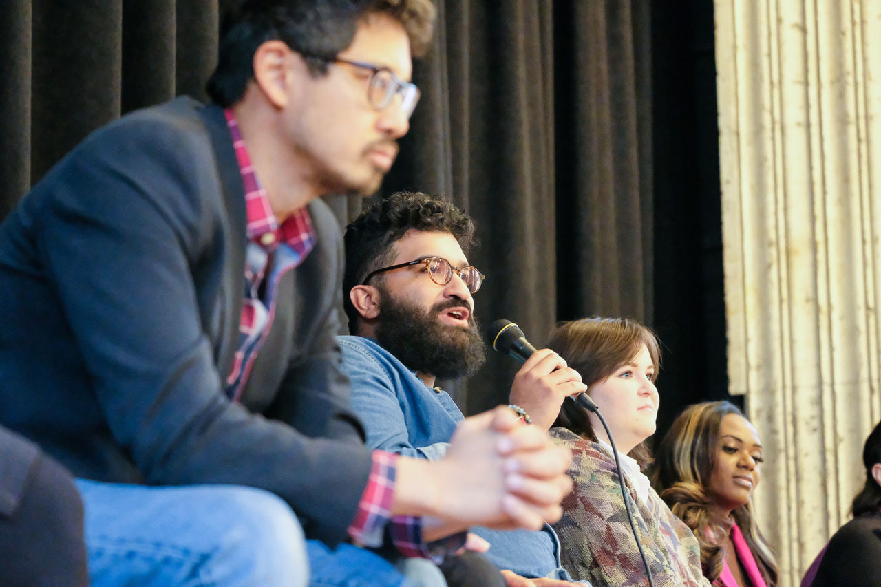 Three people on stage answer questions. 