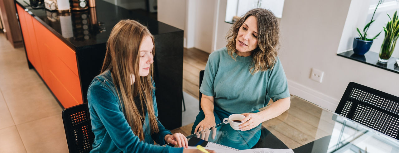 adult helping a teenager with homework