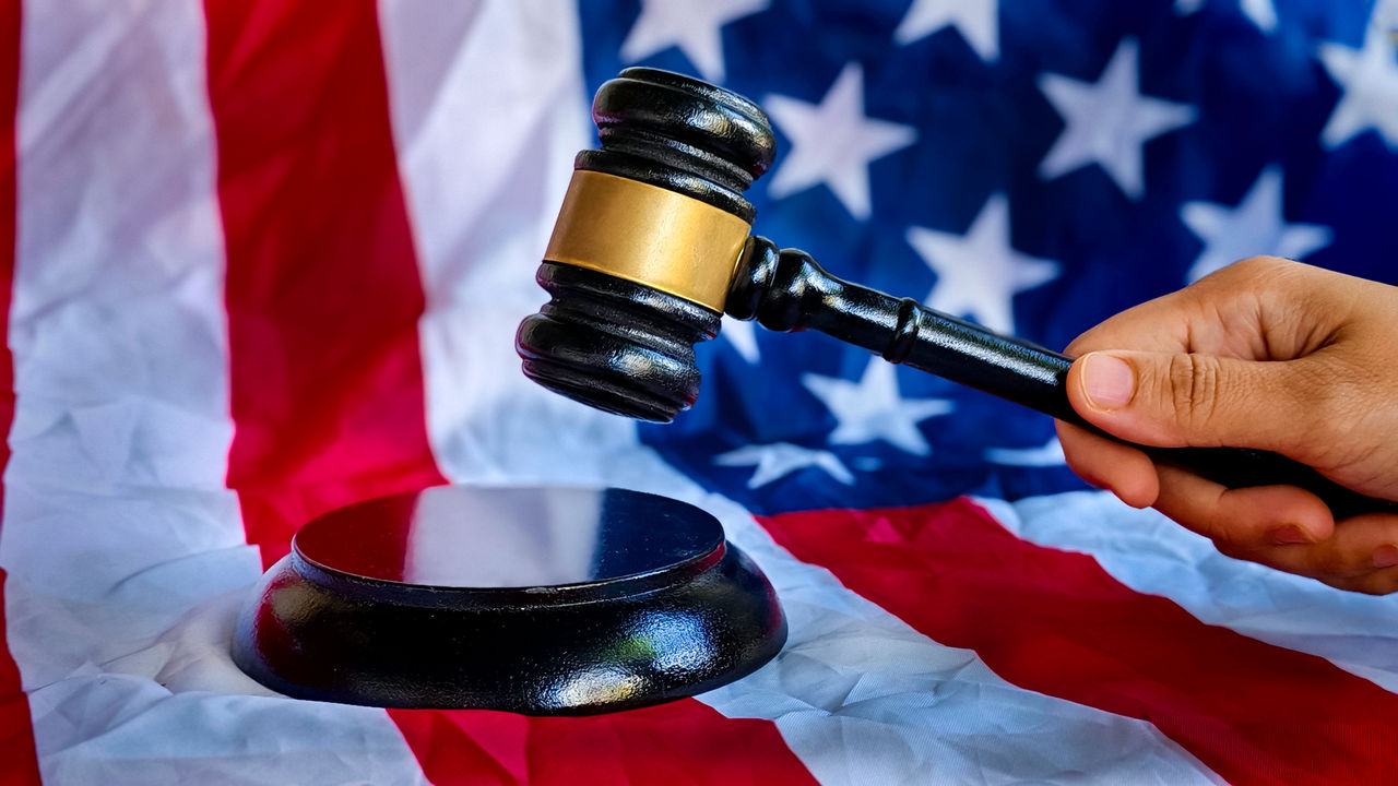 Flag in the background with hand using a gavel