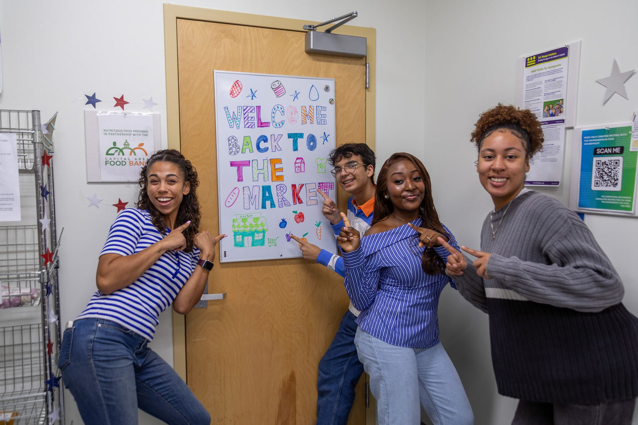 Taylor Allgood stands inside a greenhouse with a fellow Bearcats Pantry volunteer.