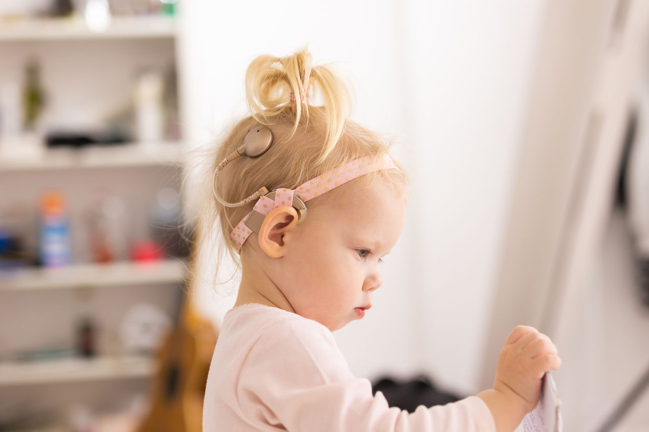 A toddler girl wearing a Cochlear implant 