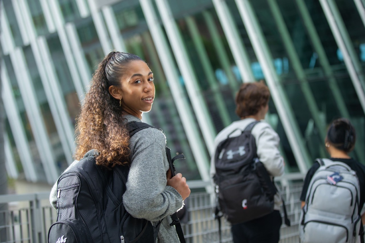 Taylor Allgood on UC campus looking over her shoulder