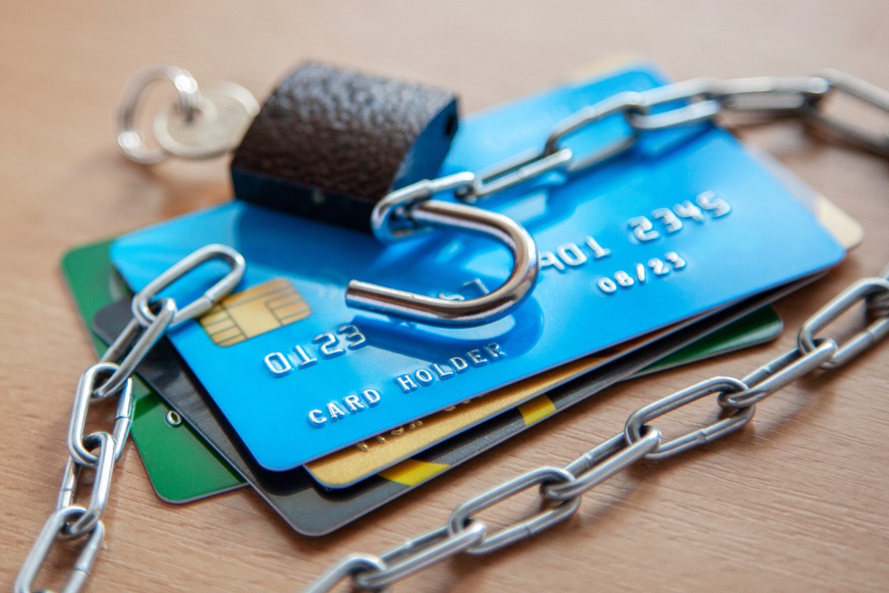 A stack of credit cards under a lock and chains.