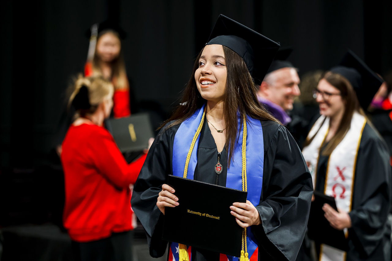 A student holds her diploma after walking on stage.