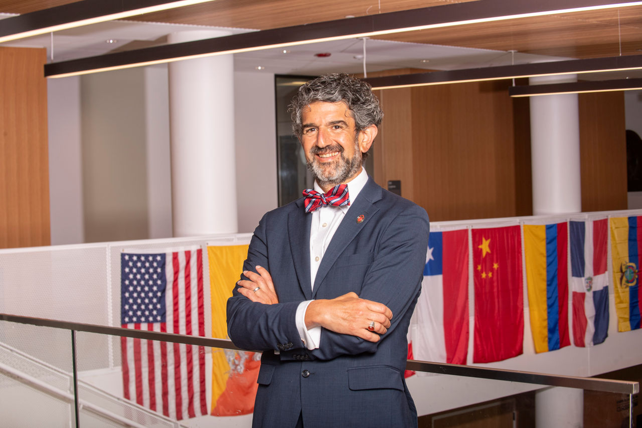 Photo of Dean Haider Hamoudi, standing with arms crossed and wearing a bowtie