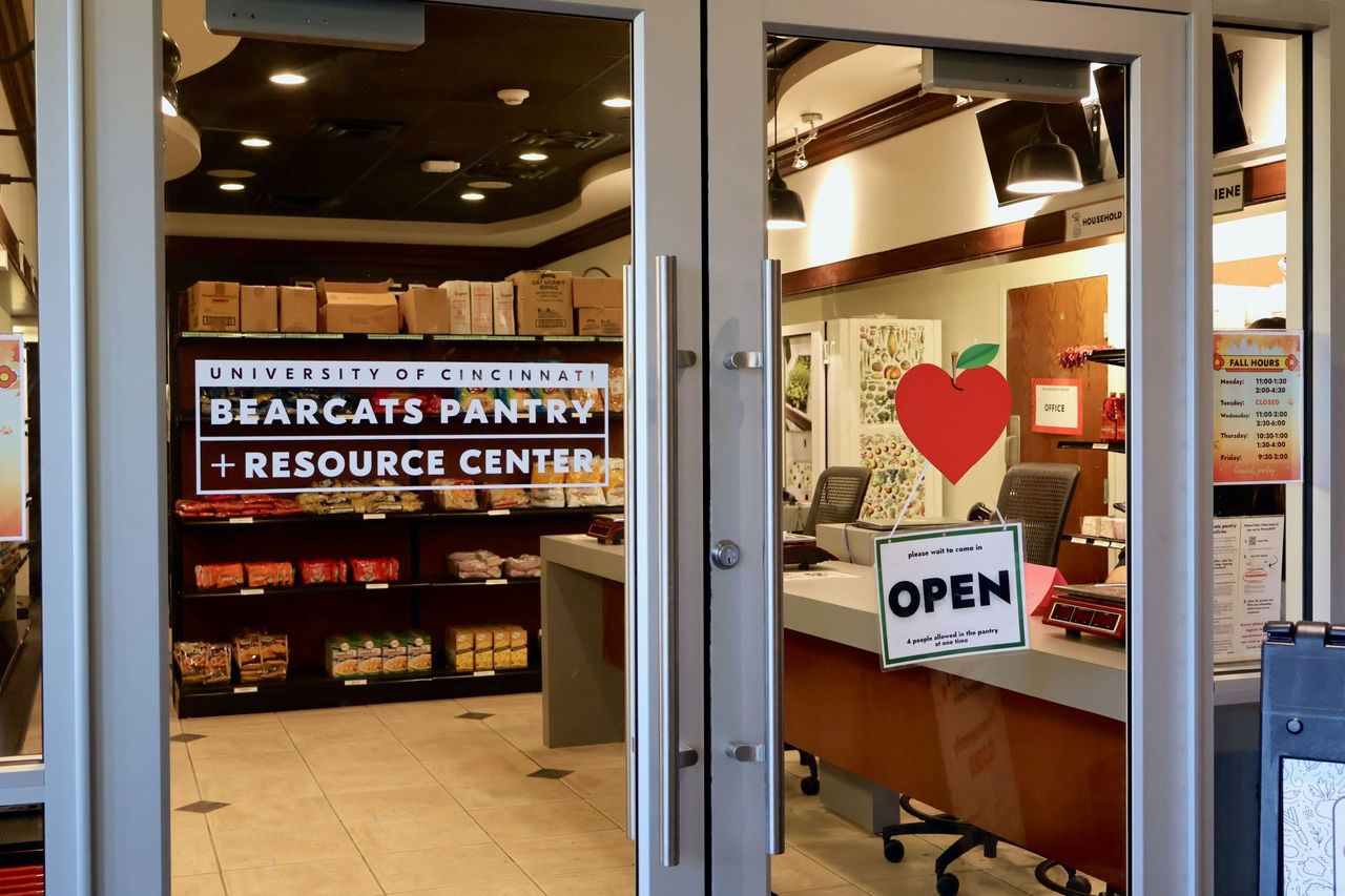 Shows front entrace of the Bearcats Pantry and Resource Center. Visible inside are rows of food items and a front desk checkout area