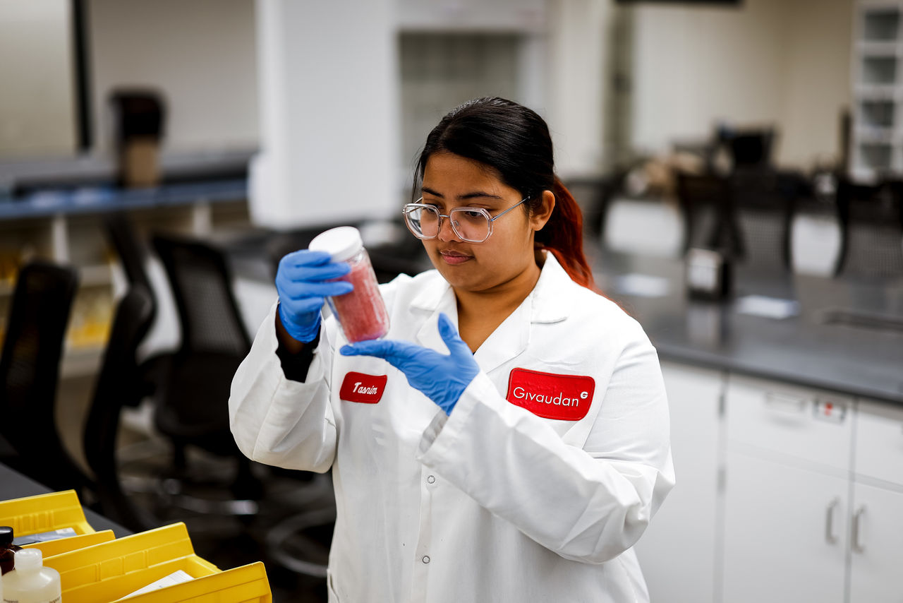 Tasnim Anower in a labcoat and gloves works in a UC chemistry lab.