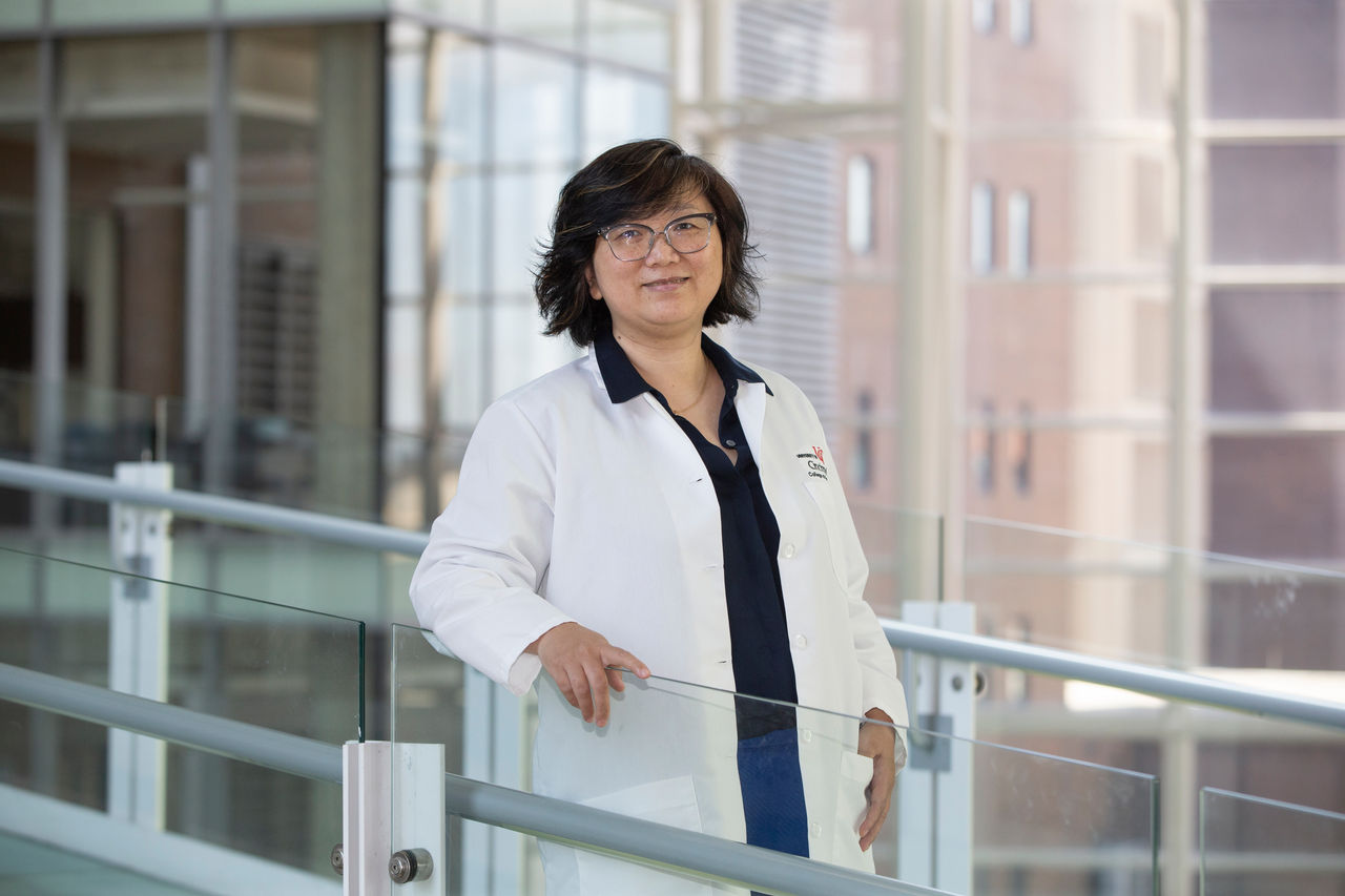 Yu (Agnes) Luo, PhD, standing on a bridgeway in the CARE/Crawley building atrium 