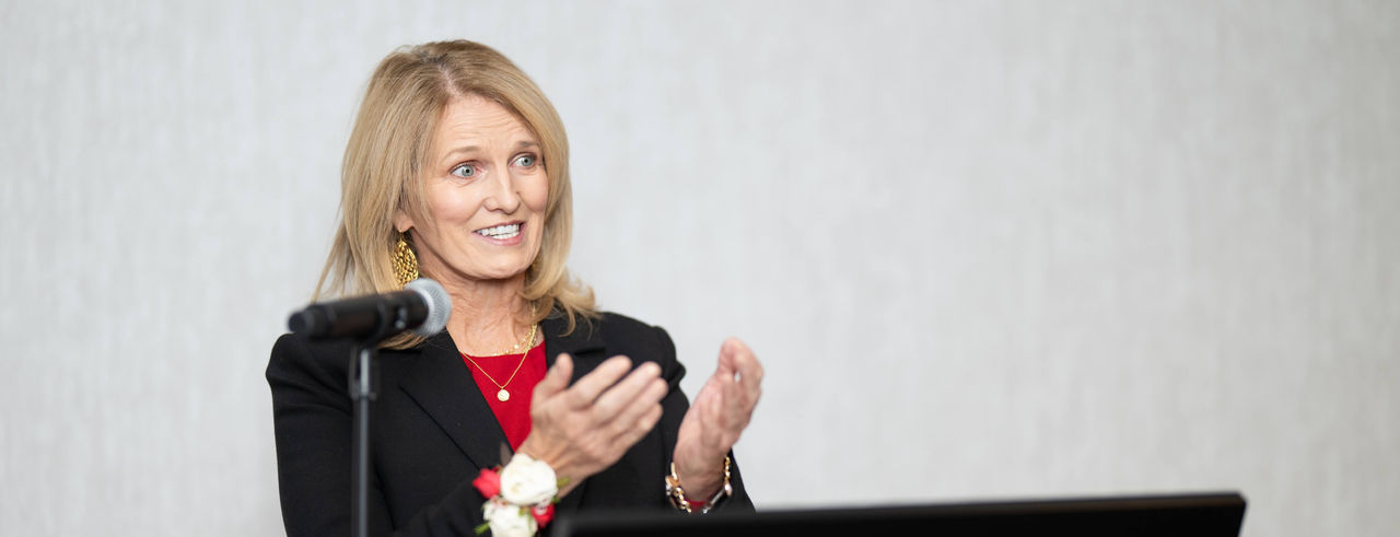 Jean Savage stands at a podium
