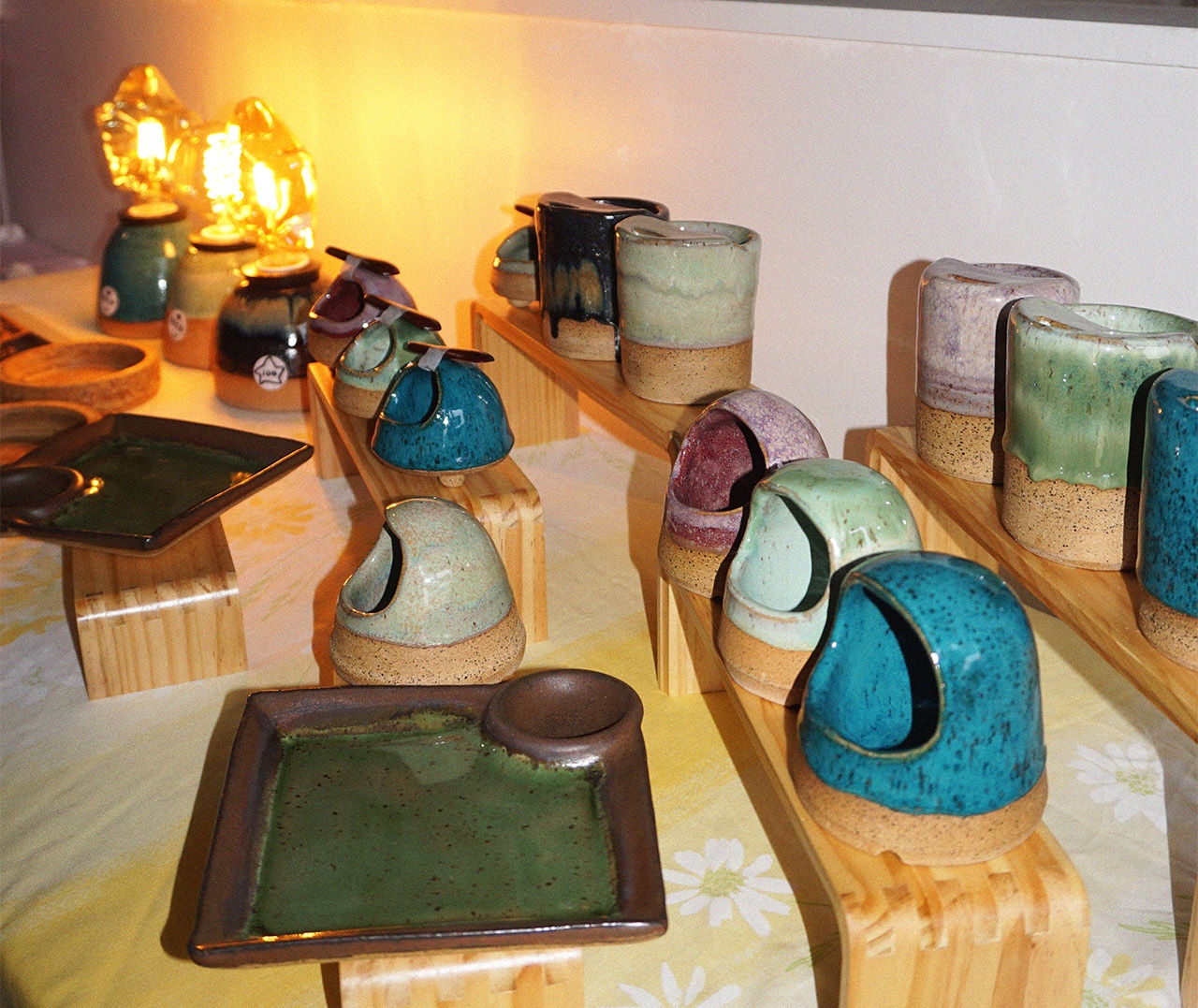 handmade ceramic mugs and lamps on a display table  