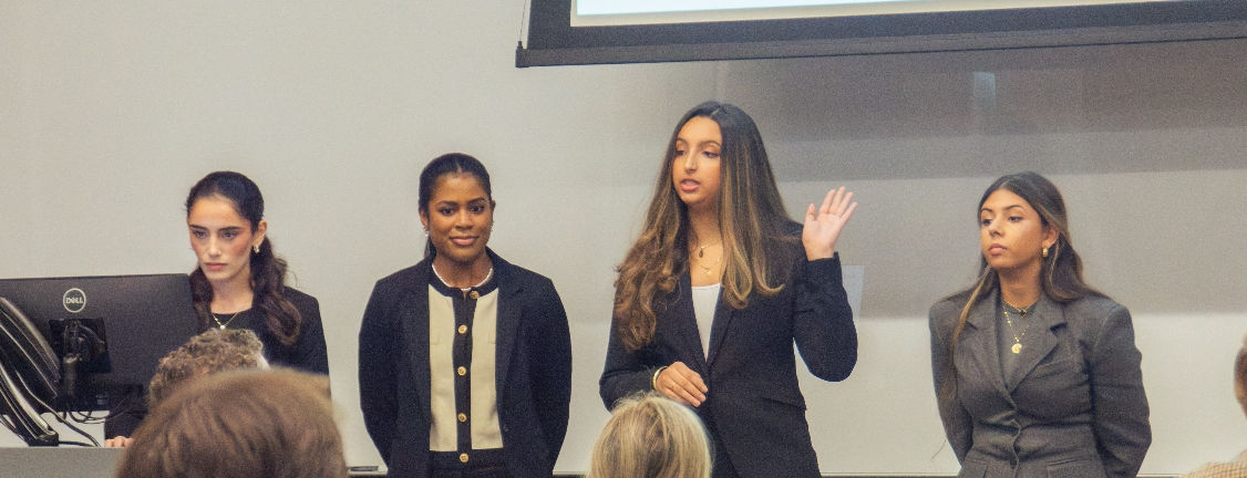 4 students presenting health policy project to judges