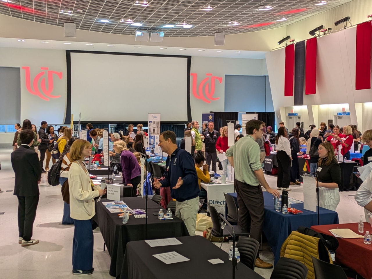 image of many students at employer booths greeting potential bosses at a job fair in TUC at UC