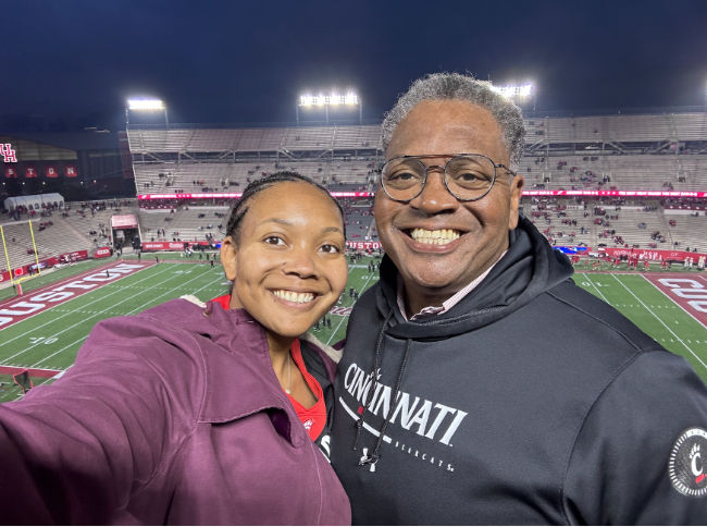 Photo of Theo Marshall and her father at a football game.