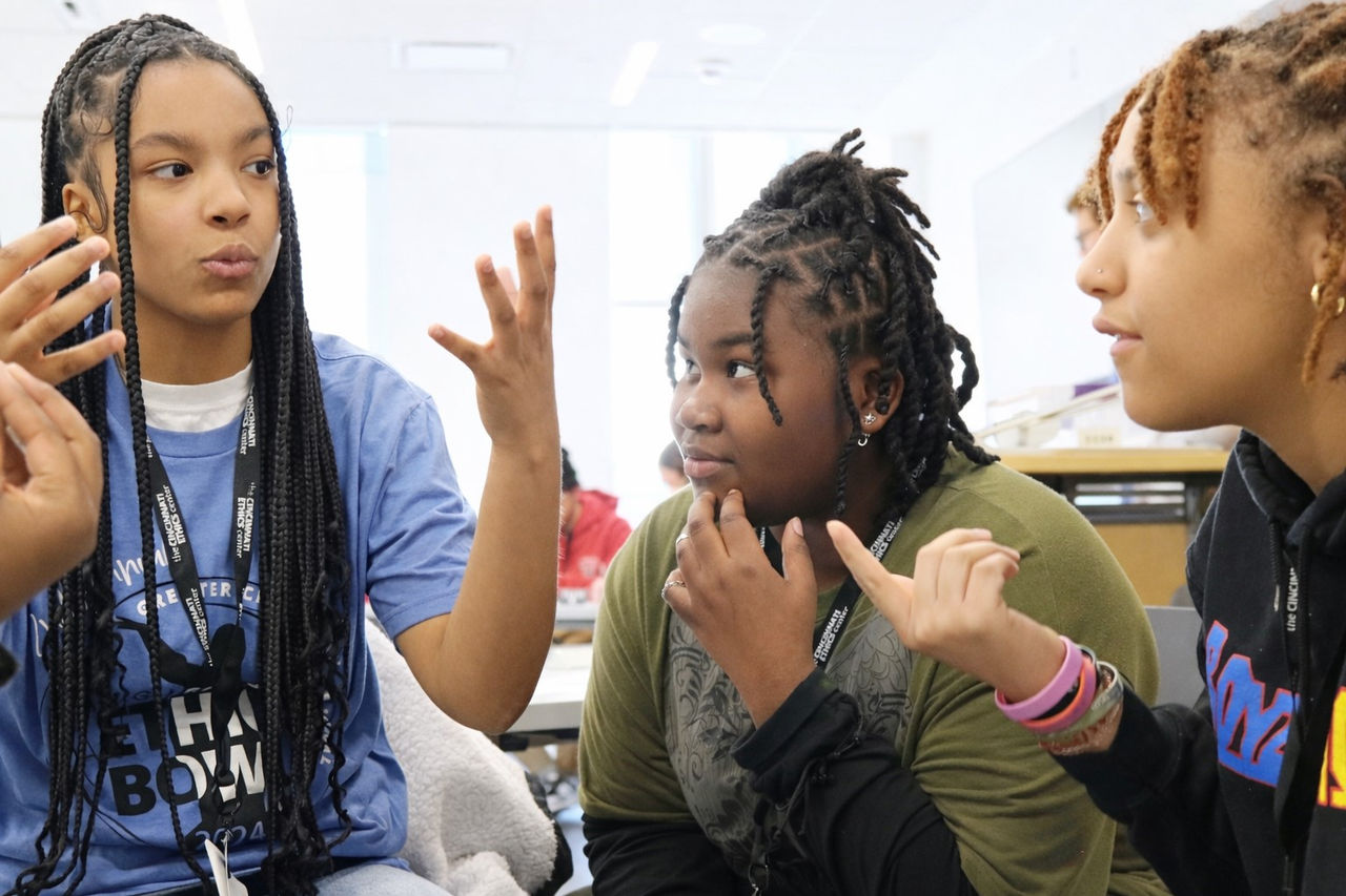 three young women from shroder high school discuss strategy while at their station during an ethics bowl match