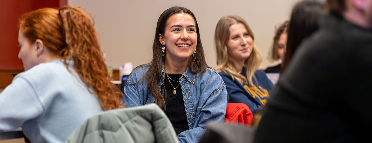 students sitting and smiling, laughing in a classroom