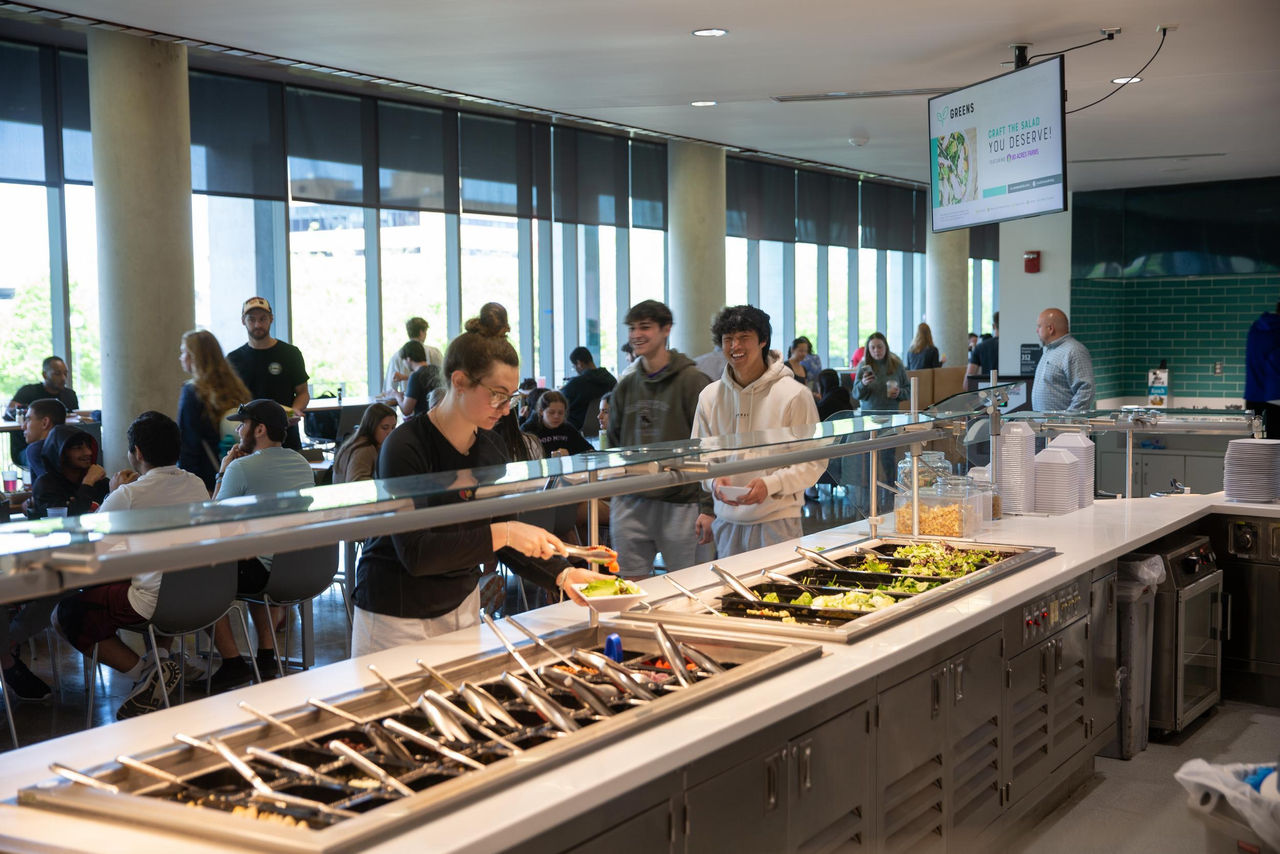image of a food counter with students in On the Green dining hall