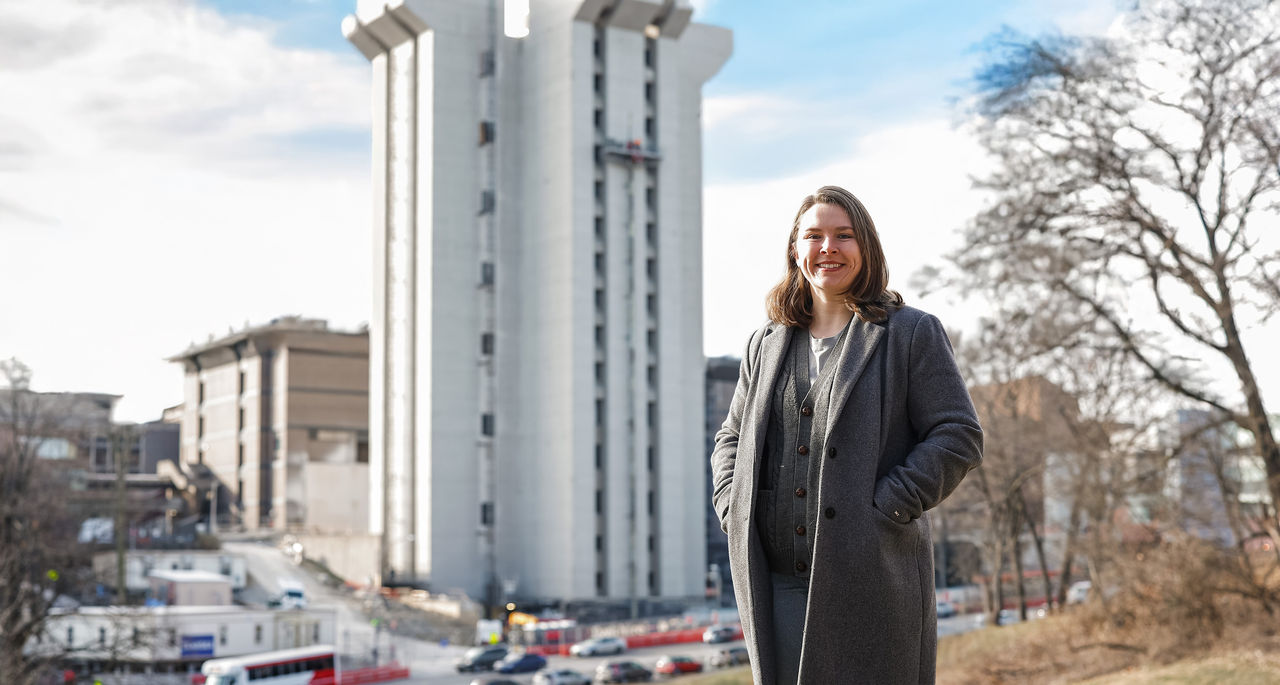Anna Hargan poses in front of Crosley Tower from Burnet Woods.