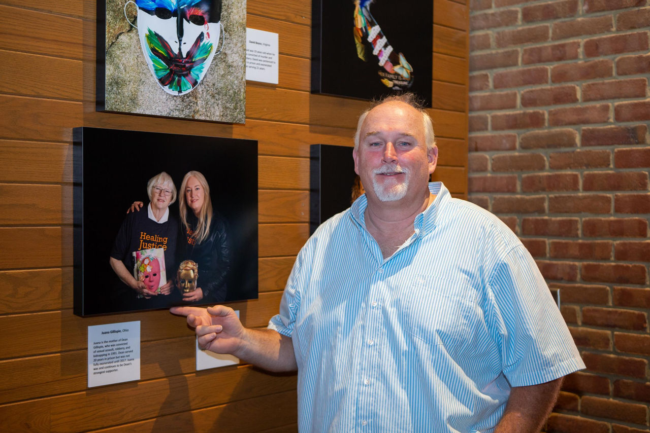 Dean Gillispie shown the UC campus standing next to a Healing through Art display