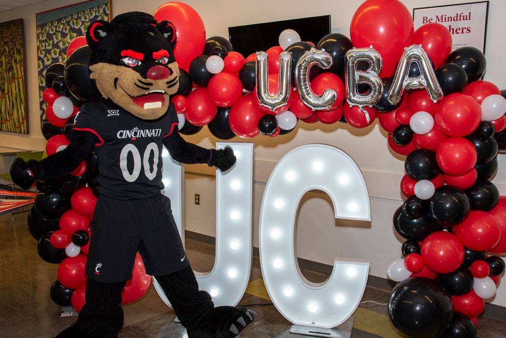 bearcat mascot with balloons and UC Blue Ash College sign