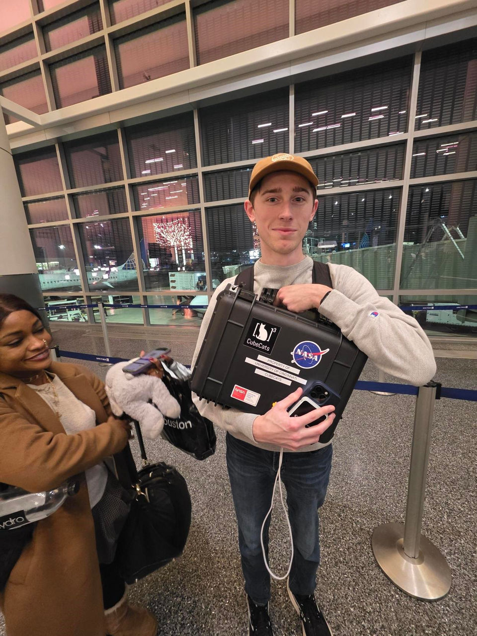 Sam Kohls in the airport, was literally attached to the case safeguarding the satellite.