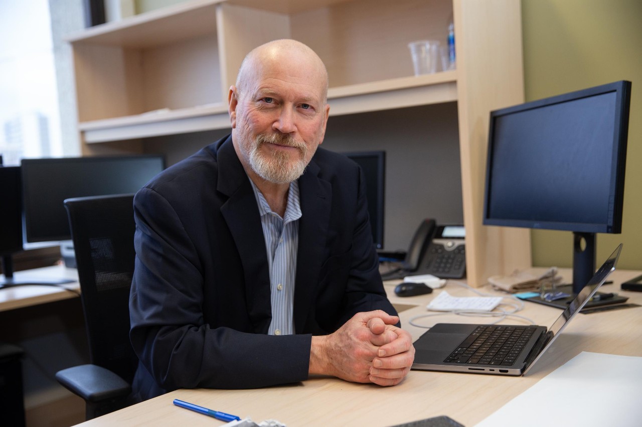 Hans Breiter talks at his desk.