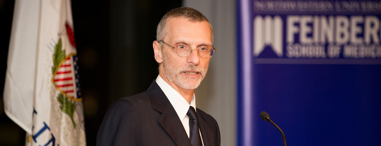 Dr. Gius speaks at a podium