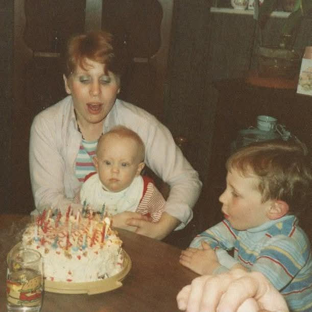 Cyndy Sellers with her young sons, Christian (left), and Cory, blowing the candles out on a birthday cake. 