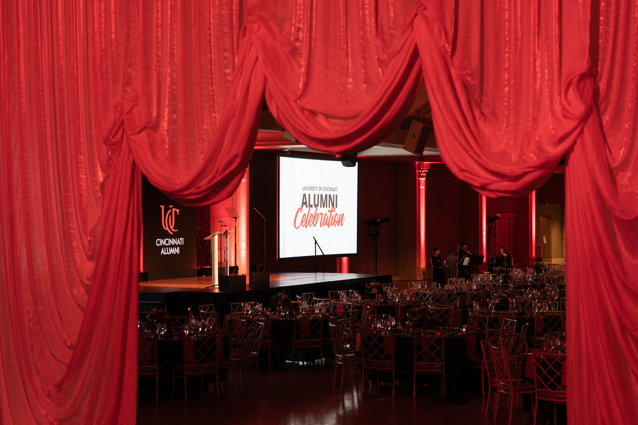 2025 Alumni Celebration stage with Cincinnati Alumni and UC Alumni Celebration on the screens