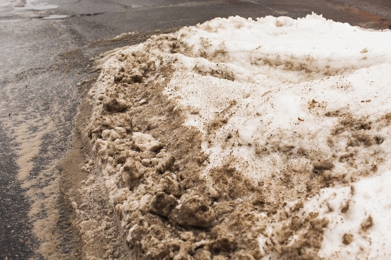 A dirty, polluted pile of snow on the side of a roadway 