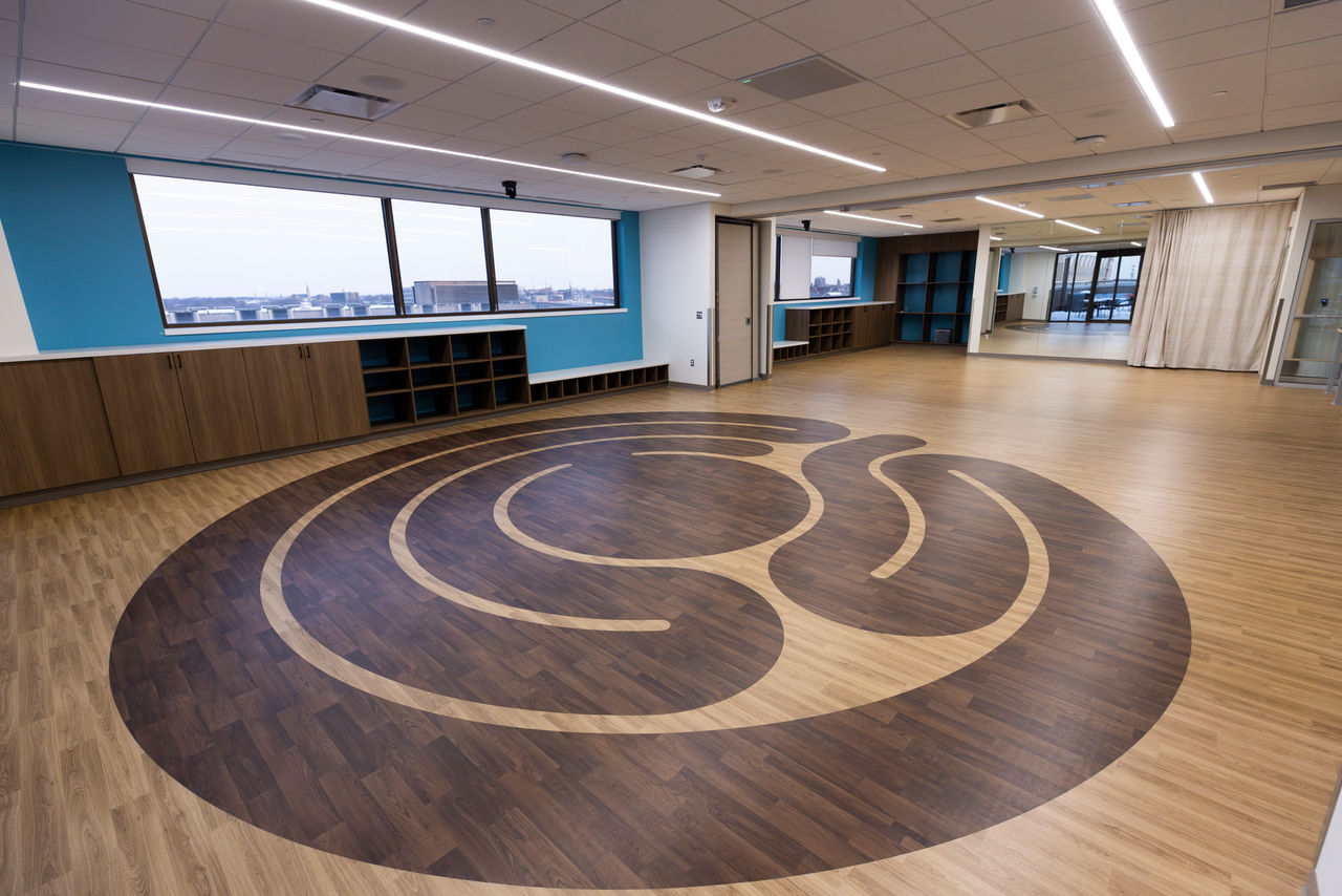 An open exercise room with a maze pattern on the wood floor