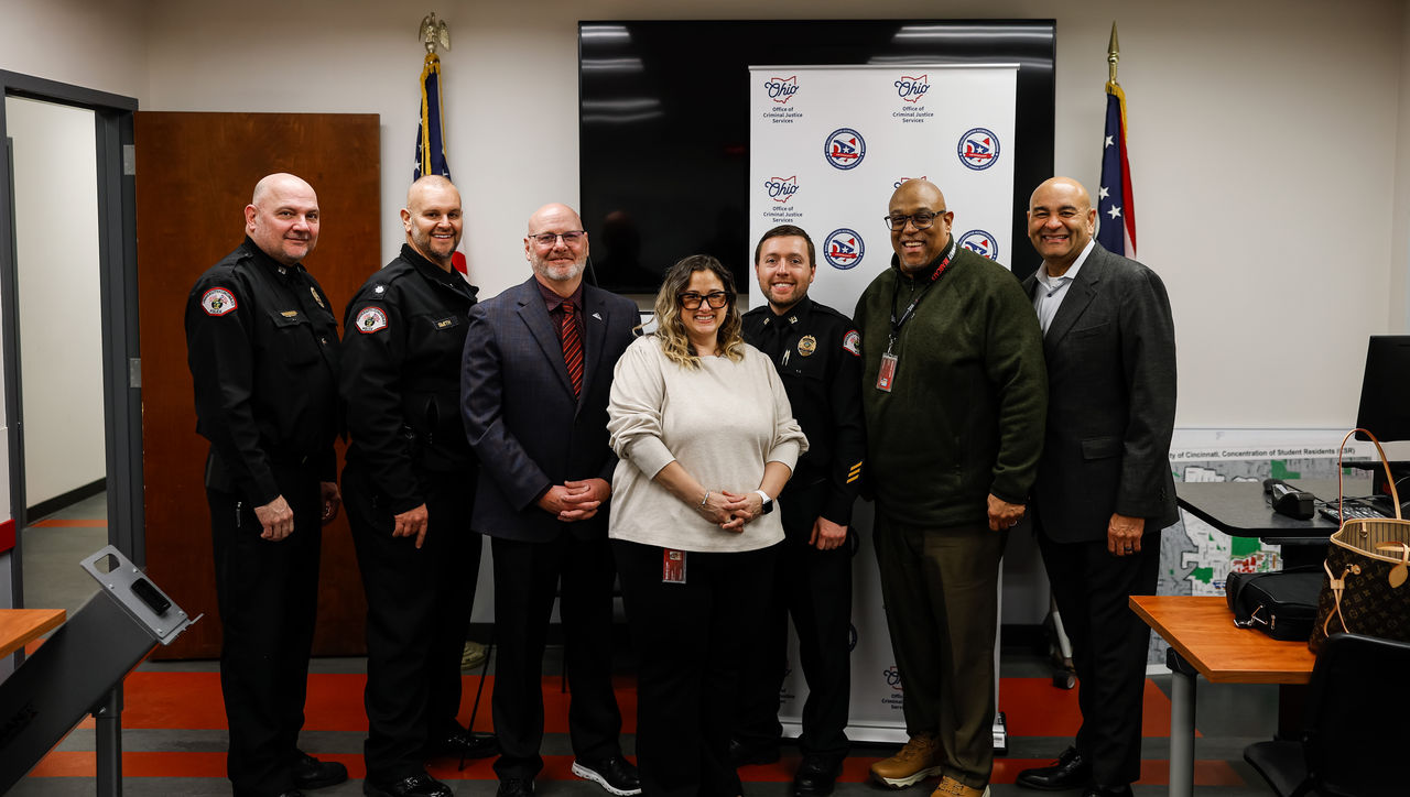Seven people stand in a posed photo.