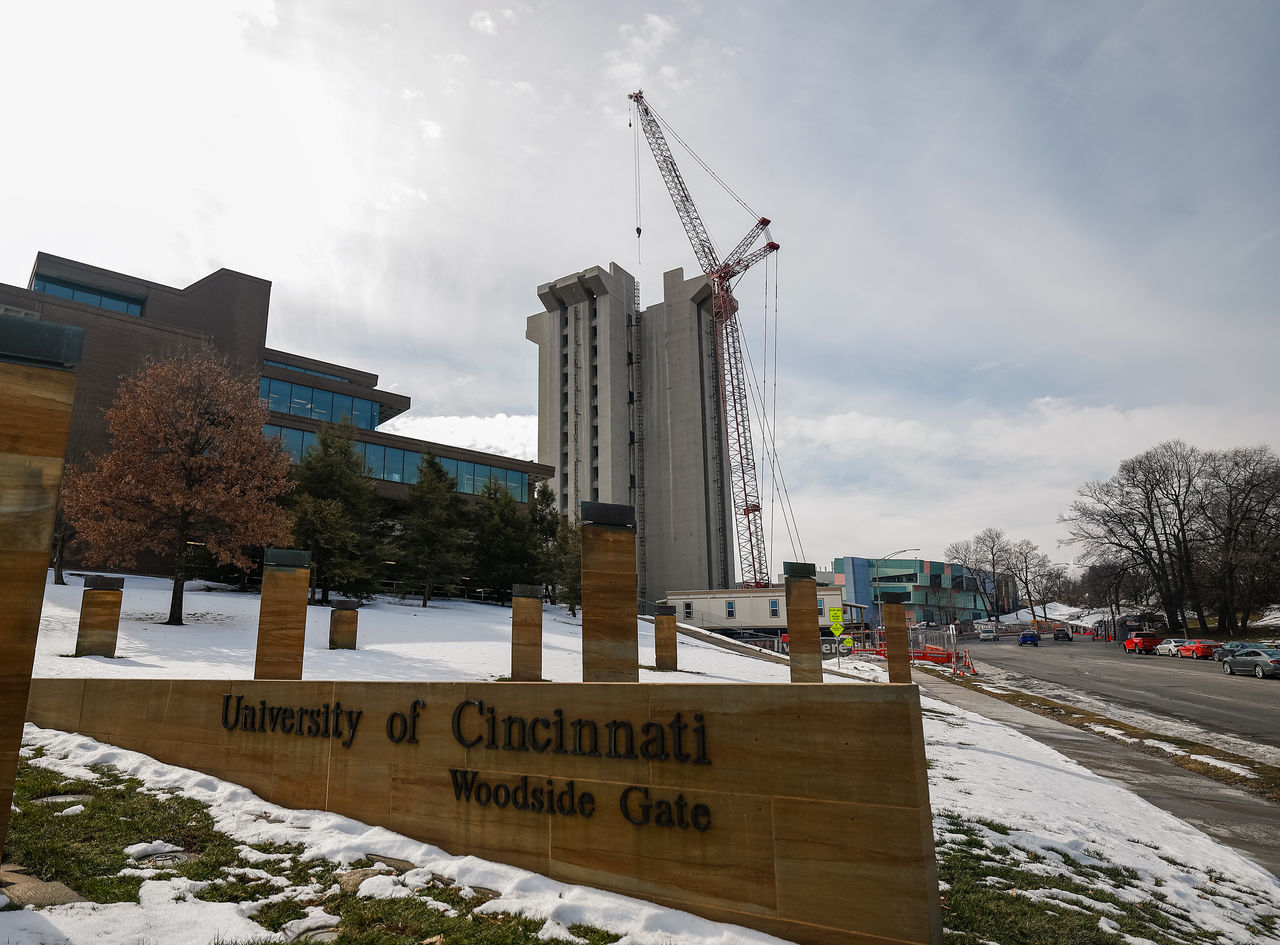 A crane looms over Crosley Tower which has some of its topmost sections missing.
