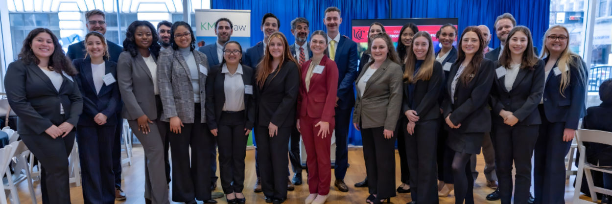 Students standing in a row taking a photo with the UC Law Dean Haider Ala Hamoudi.