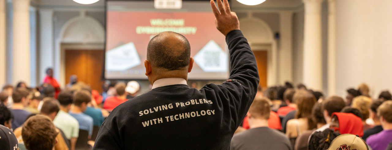 Hazam Said pictured from the back wearing a shirt that reads Solving Problems with Technology