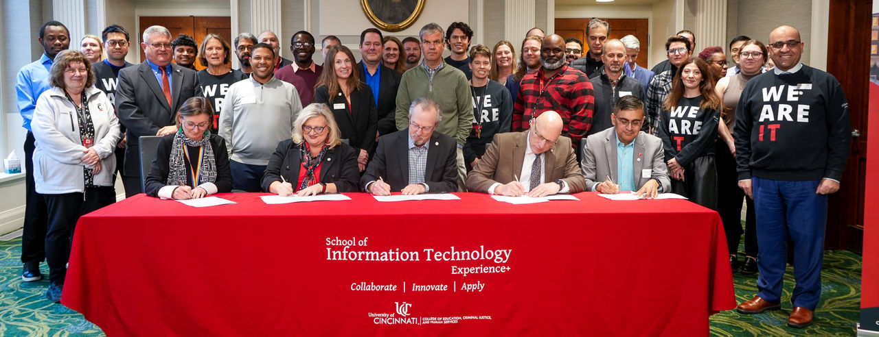 group of UC and CIO officials sign a collaborative agreement in a signing event