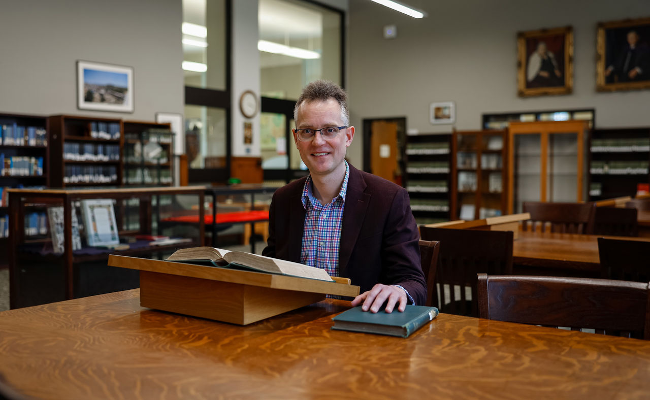 Matthijs Wibier poses at a desk in the Blegen Library of UC Classics.