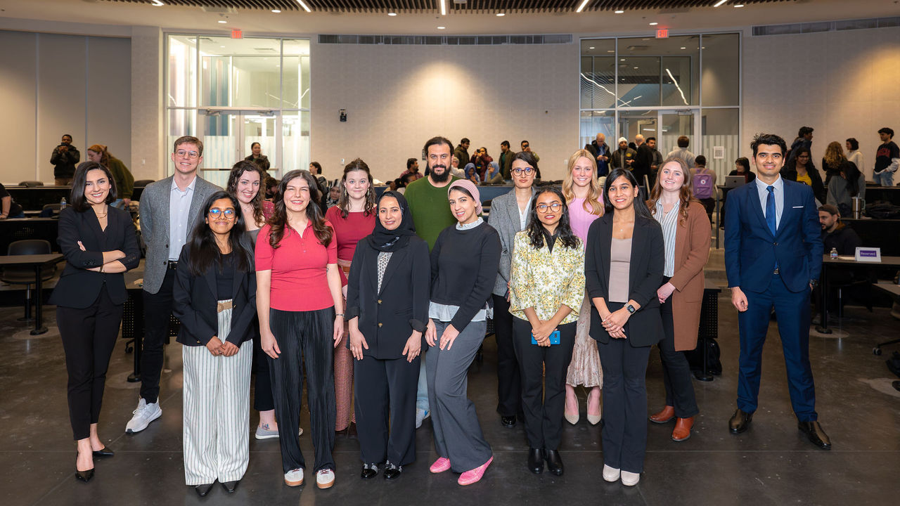 Fifteen UC graduate students shown posing for a photo at the 3 Minute Thesis Competition.