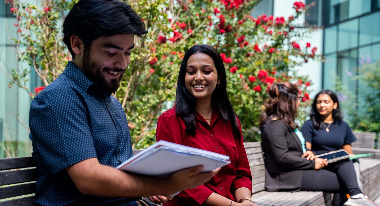 UHP students talking while seated on a bench